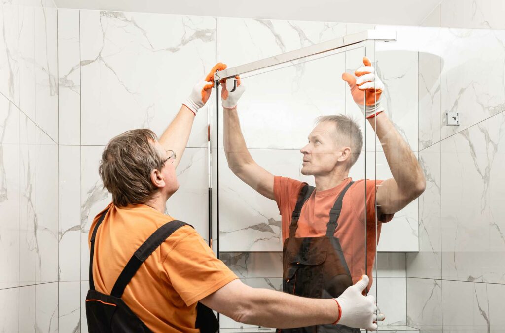 2-men-putting-up-a-glass-shower-wall