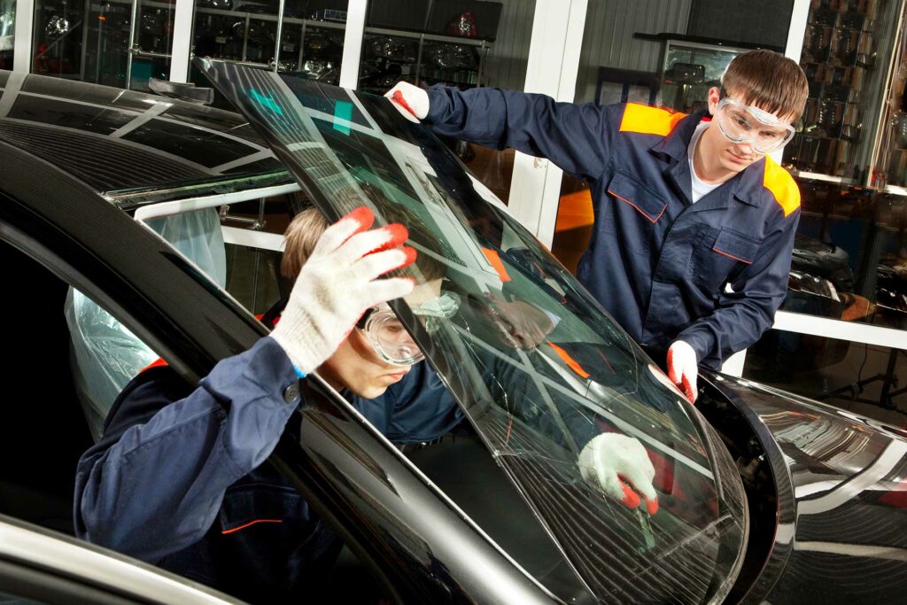 technicians replacing a windshield