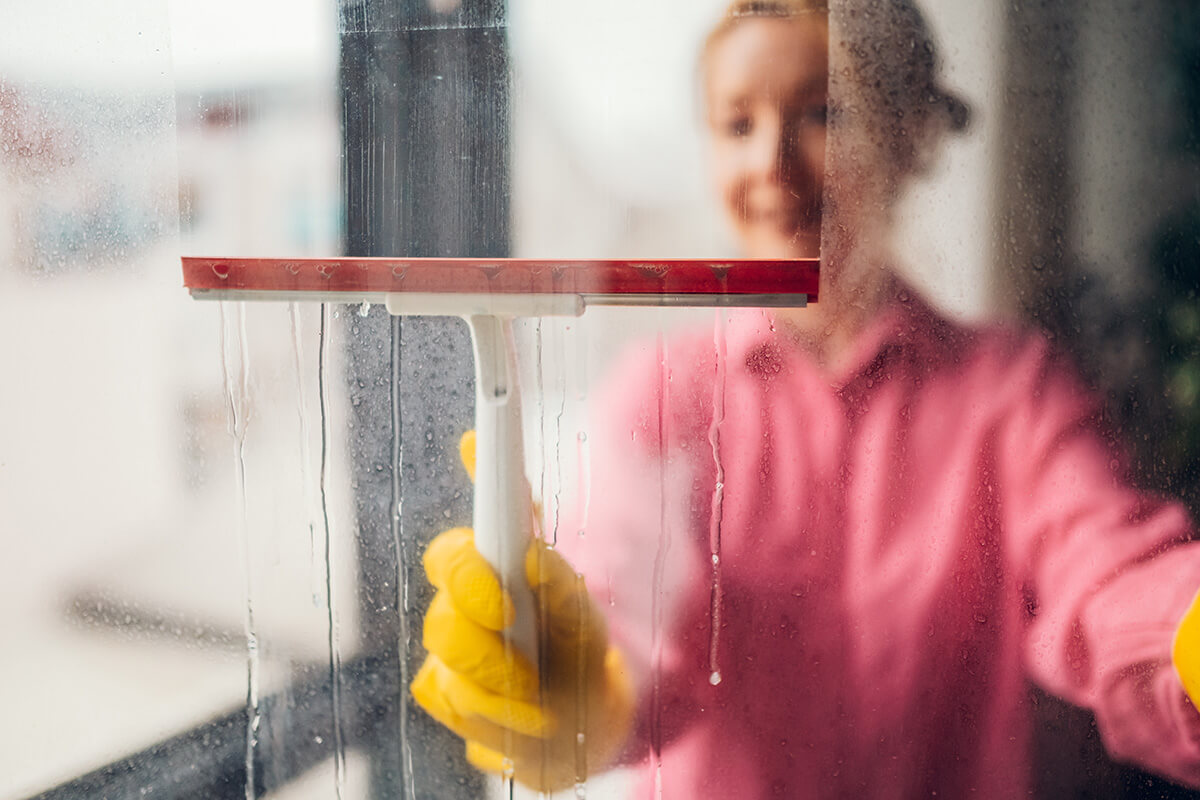cleaning a window with squeegee