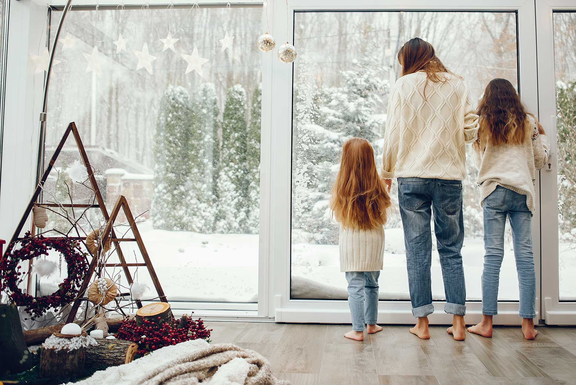 mother-with-children-at-home-looking-out-at-snow